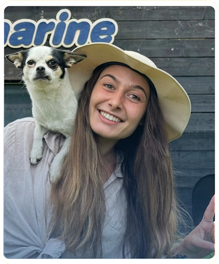 A Zoomarine un'addestratrice saluta sorridendo con un cane sulla spalla